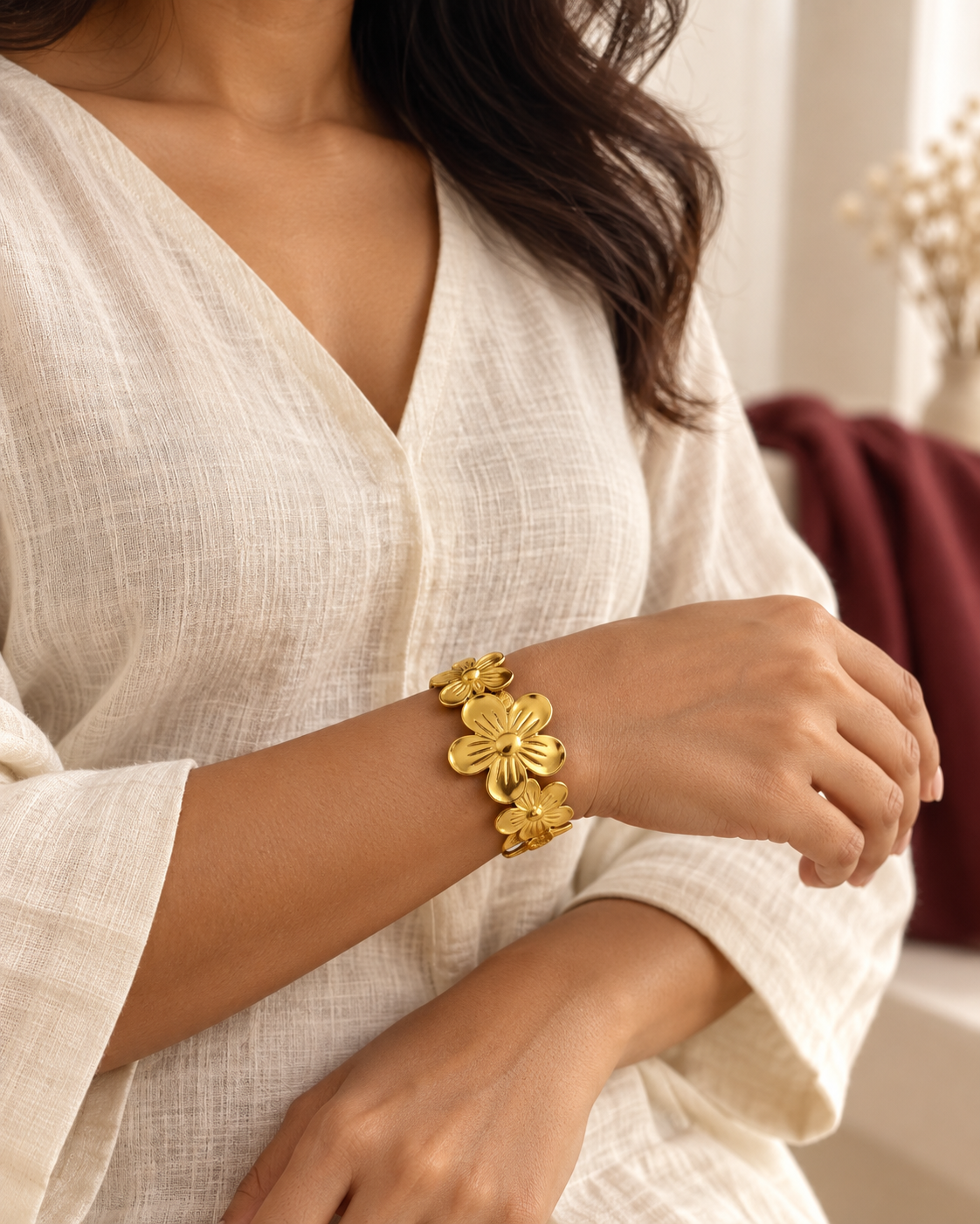 Model in an ivory blouse wearing the five-petal floral bracelet