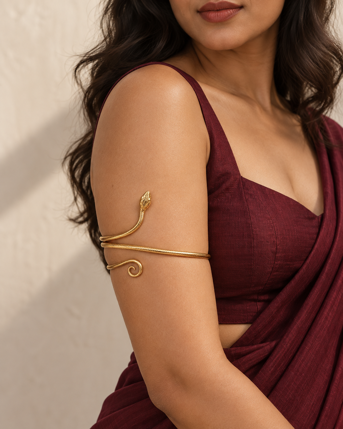 Model wearing the textured serpent arm cuff with a wine blouse